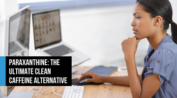 Woman working focused at a dual-monitor desk, concentrating on her screen — representing clean cognitive energy and mental clarity from paraxanthine.