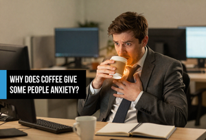 Young professional man at his desk gripping a coffee cup with visible tension and anxiety — illustrating overstimulation and nervous system strain from too much caffeine.