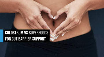 Woman forming a heart shape with her hands over her bare abdomen, with text overlay reading Colostrum vs Superfoods for Gut Barrier Support