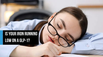 Tired woman resting her head on her arms at a desk.
