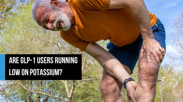 Older man outdoors holding his leg during a muscle cramp.